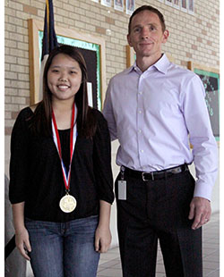 Eunice Lee, next to Principal John Sloan, has recently been recognized as an outstanding performer. Competition was a cool experience, Lee said. Lee won a gold medal at the Texas State Piano Contest.