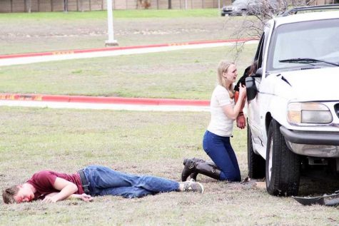 In despair, senior Lexi Breed clutches the arm of Shattered Dreams victim senior Reagan Head during the crash scene on March 12. Senior John Tolander (left) and Biology teacher Brent Grissom (not pictured) were also killed.