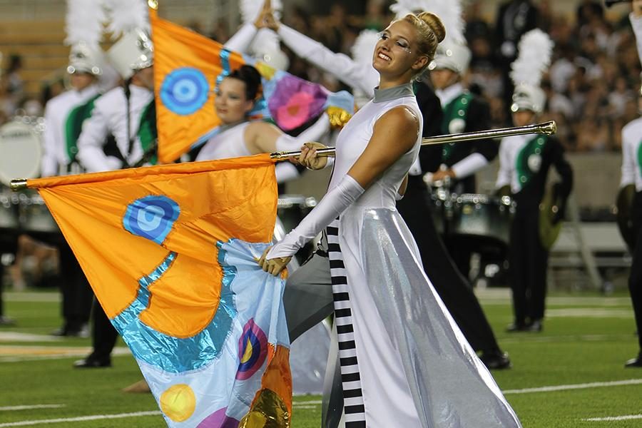 At the Football game against Aledo on Aug. 28 senior co-captain Savannah Shadle twirls her flag during the half time show. The Painting with a Twist fundraiser will go towards buying the new flags and costumes that the guard needs every year. I love the social aspect [of Painting with a Twist]. said Shadle. Everyones laughing and eating, its so awesome.