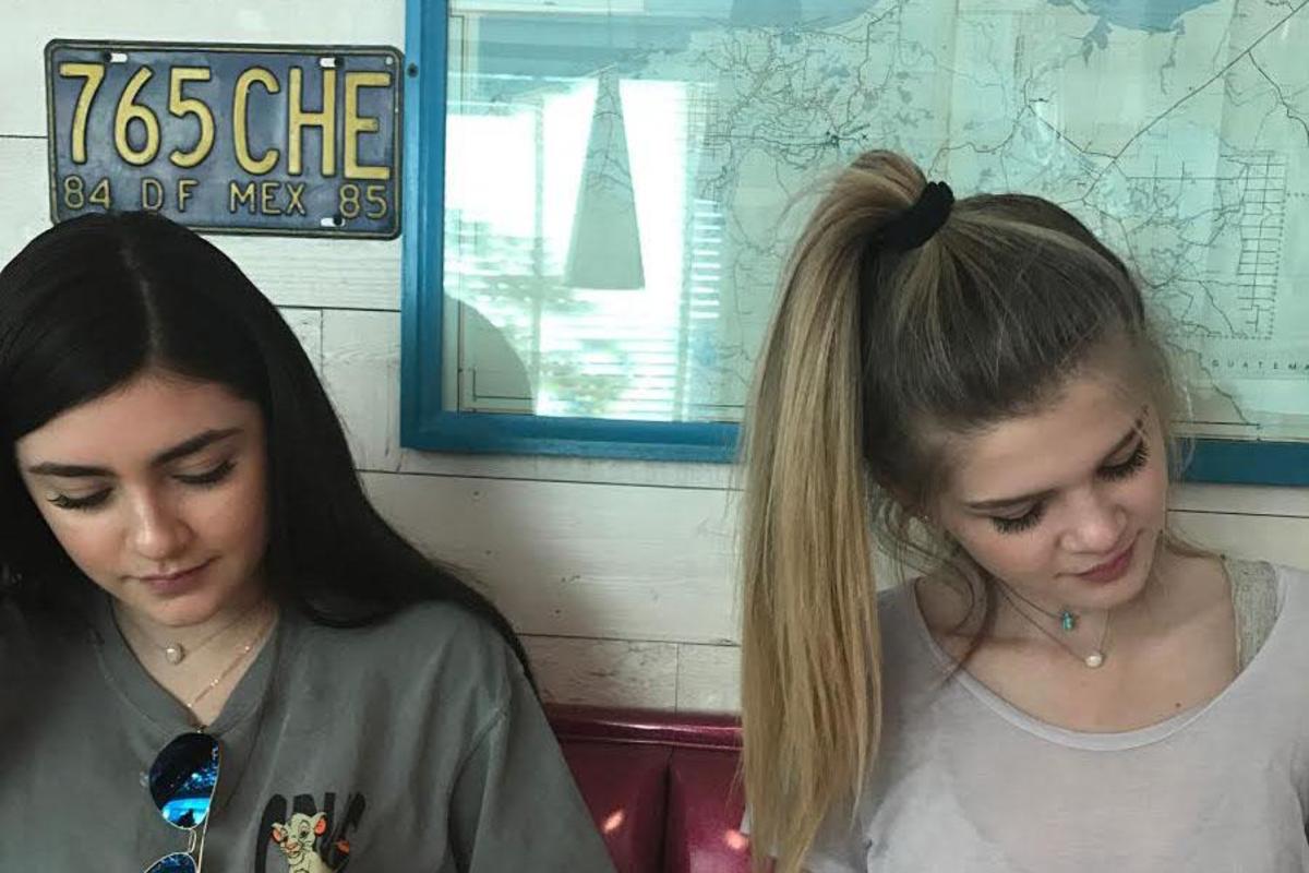 While at the grand opening of Chuy's, senior Vannesa Martinez and Hanna Stapleton look over the menu.