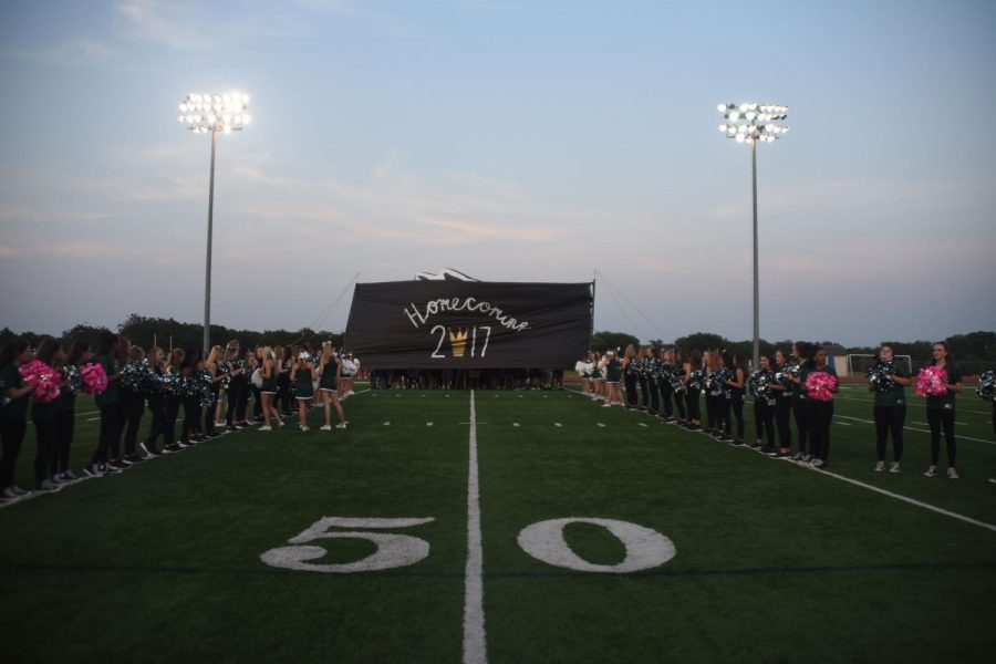 Cheer holds up a homecoming banner during the pep rally on Sept. 13.