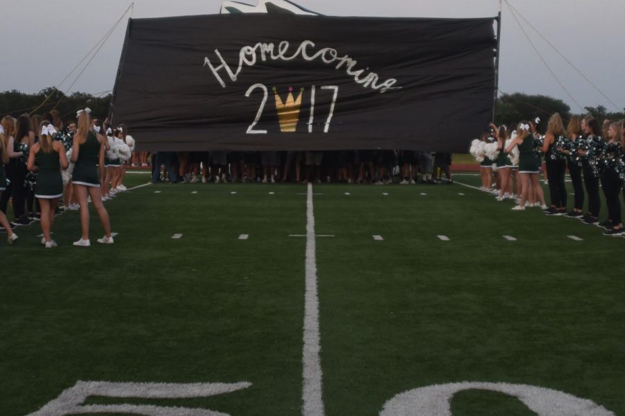 Cheer holds up a homecoming banner during the pep rally on Sept. 13.