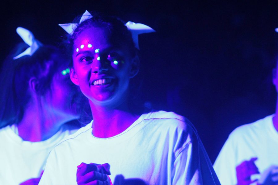 Glowing in her face paint and white shirt, sophomore Abby Mitchell cheers at the annual black light pep-rally on Nov. 3.