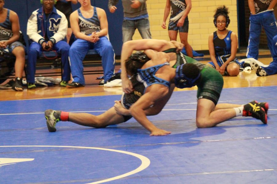 CPHS varsity wrestler Luke Eledge battles it out on the mats with a wrestler from McCallum High School.