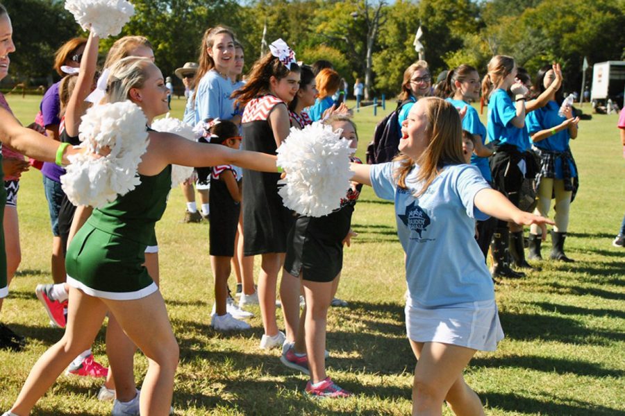 Greeting the other cheerleaders, senior Jordan Hagemann participates in the the 
 Buddy Walk hosted by the Down Syndrome of Central Texas. Hagemann is an ambassador with the association.