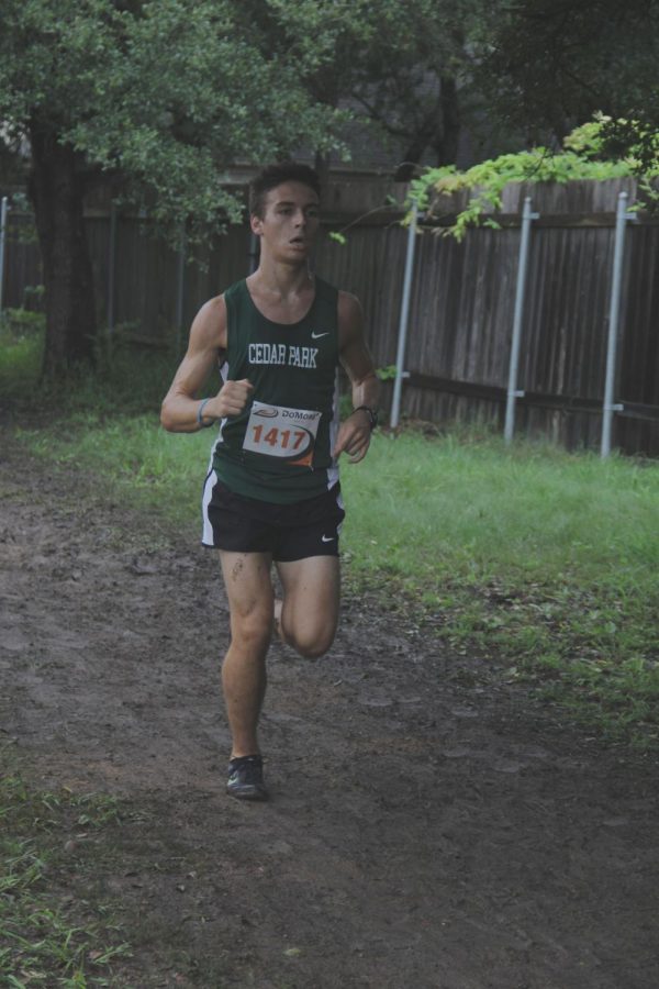 Dashing through the dirt, junior runner Tanner James looks to finish the CP Invitational strong. The Cedar Park Invitational was super muddy which made the run pretty difficult in some areas, junior runner Tanner James said.  