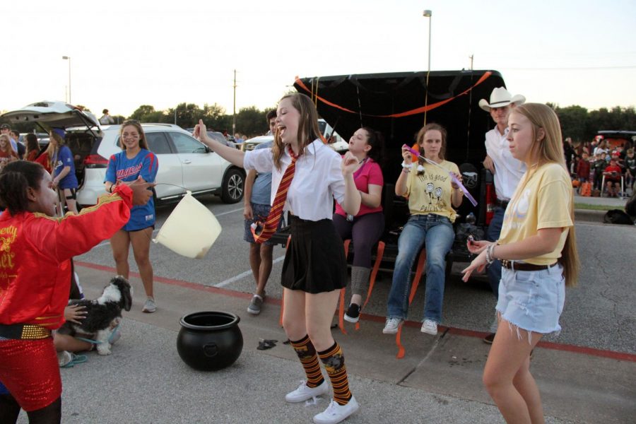 Jumping around and leaving her wand behind, senior Carlie Dill dances in her Hermoine Granger costume with the kids attending Trunk or Treat on Oct. 26. This is Dills first year being in PALs, and said that she was very excited to participate in Trunk or Treat with the organization. “I loved seeing how all the little kids interacted with us,” Dill said. “All of them were so excited for high schoolers and candy, it makes us really happy that we do it.”