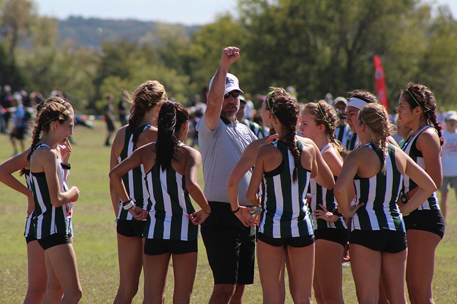 Coach Grenier talks to the girls XC team before they compete in a meet.