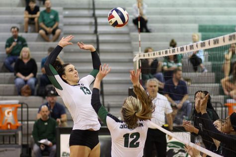 Senior varsity volleyball player Shelby Epley hits the ball over the net.