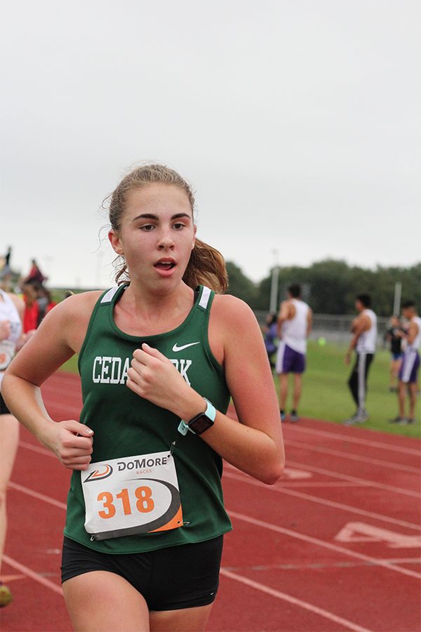 Keeping pace, sophomore Anna Maib runs on Sept. 15 in the Cedar Park Invitational for cross country on the Cedar Park track. Maib competed against schools from around the area, and the girls team came out second overall. “The invitational is so important to the team because it is such a large meet with so many schools from all over,” Maib said. “It really gives us the opportunity to showcase what skills we have, and also to challenge us and show us where we can improve.”