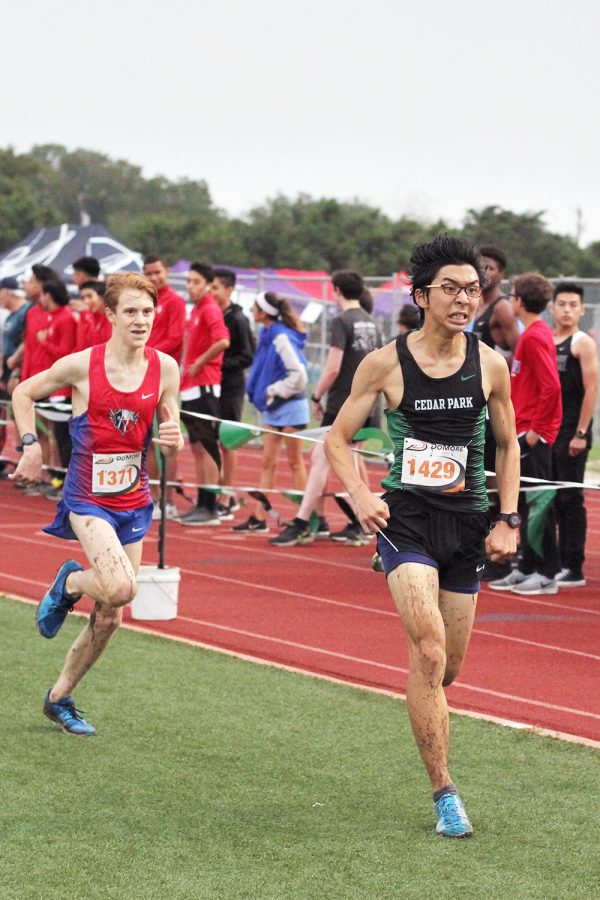 Just feet ahead of another runner, senior Alden Yi pushes through during cross country’s Cedar Park Invitational on Sept 15. The boy’s team scored third place overall at the invitational. “You have power over what you can do for the finish,” Yi said. “I always strive to finish strong in every race no matter what type of conditions there are to bring me down.” 
