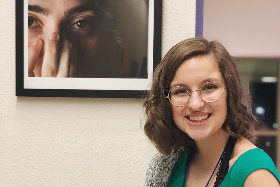 Sydney Deen poses in front of her piece in the Re[Imagine] art show on March 2. I started to see my work as not that of a child playing with equipment they didnt understand, but that of a capable student who is proficient with a  camera, Deen said.