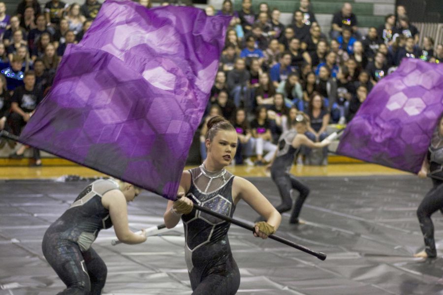Senior co-captain Jamie Bailey performs Endohedral with the color guard at the Cedar Park Classic competition on Feb.23. According to Bailey, Endohedral is darker than past routines the color guard has performed. “For all of winter season we work on perfecting our show which is around four and a half minutes long,” Bailey said. “[The routine] is about being trapped so we use our props almost like the cage [is] trapping us.”