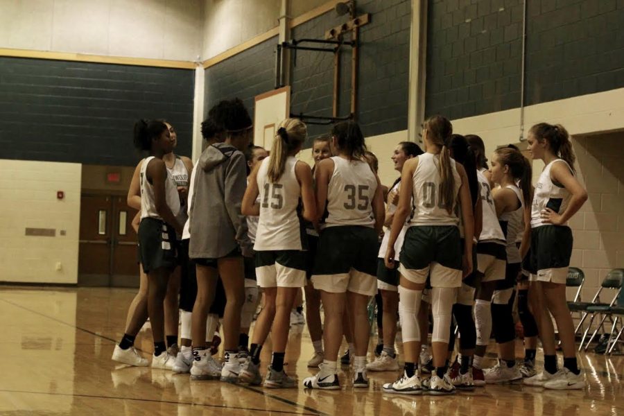 The JV team huddles around seniors Takara Holst and Nicole Leff during a timeout at Fall League game vs. Lake Travis. The teams, Freshman, JV, and Varsity, all came out on top of their Lake Travis games. The younger teams look up to the returning players for support and example during Fall League and even into the season. Bringing back girls that have the best chemistry together allows the teams to create their own flow during every game, head coach Donny Ott said. 