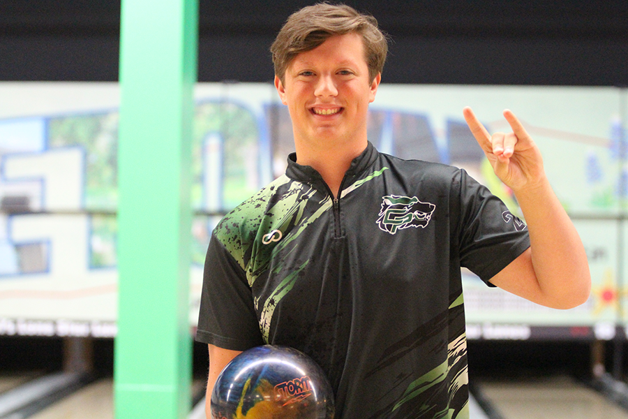 Putting up a T-wolf, senior Ian Cheek poses before the meet. The team defeated Vista Ridge 27-2. I personally know that we are one of the best teams and we are what makes the division the hard division, Cheek said. As long as we bowl well as a team, I am not worried at all. 