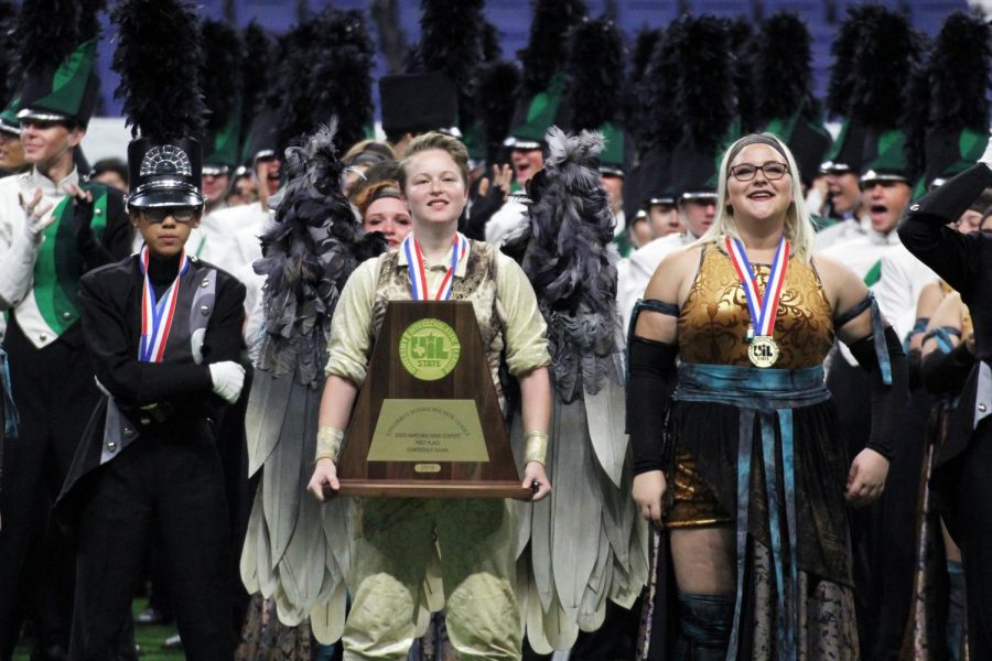 Surrounded by her fellow band members, sophomore Kierstyn Born holds the UIL state championship trophy. Born played Icarus in this years show. She said that although she was nervous leading up to finals, afterwards she felt confident in their performance. I was thrilled because I genuinely thought that was the best we had ever done, Born said. 