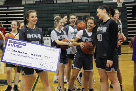 Walking towards her family, senior varsity basketball captain, Takara Holst, smiles while holding her scholarship check on Jan. 23. Holst received the scholarship as part of the KVUE Scholar Athlete of the Month Program.