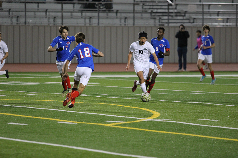 Freshman Striker/Midfielder Kei Tsujii dribbles the ball around Leander defenders on Jan. 7. Tsujii and Freshman Tyler Kukla both made varsity boys soccer this season. I have to make sure that Im never content with what Im doing and do my best to keep improving, Tsujii said.
