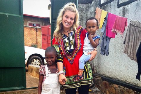 2014 alumna Taylor Lavine poses with children in Africa, where she lived for a month.