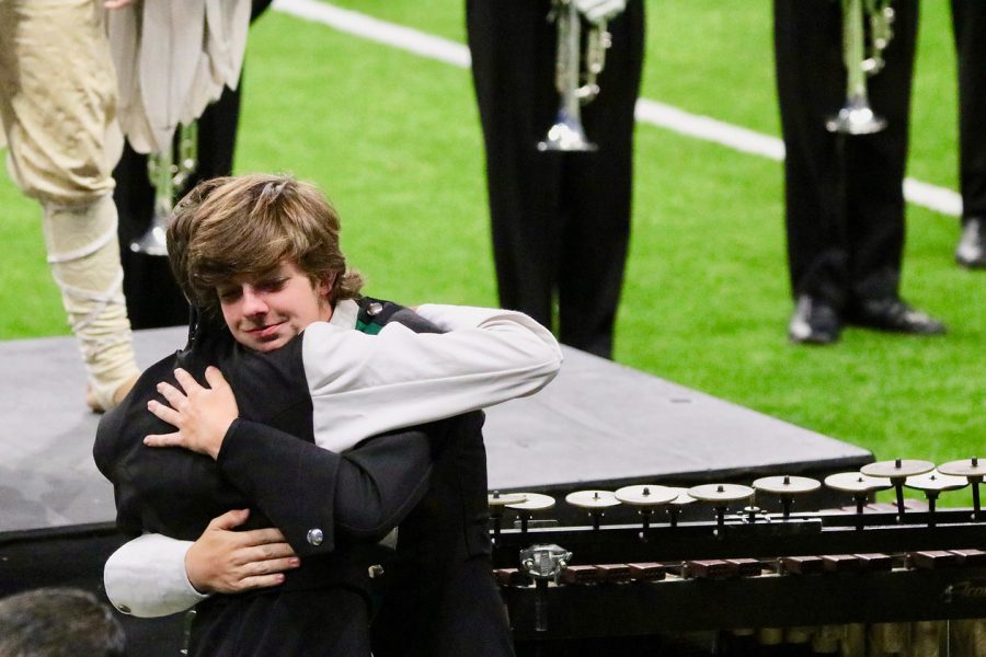 Hugging it out, seniors Cole Sylvester and Jonathan Kauffman wish each other the best run before the state finals performance. This performance earned them their second state championship. Music affects people, even though no one really knows how, Kauffman said.
