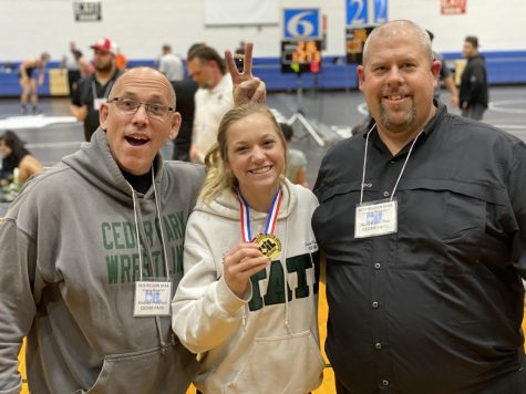Posing for a picture, senior varsity wrestler, Cassie King, stands with coaches Andrew Peterson and Beau Barksdale. King was awarded the regional champion medal on February 15, and according to her, her coaches and their attitudes are what helped her succeed. “Their strive for being better than great is remarkable,” King said. “They never eased up on me and always pushed me to be the absolute best. It was another standard that they expected me to achieve because they never wanted me to settle.