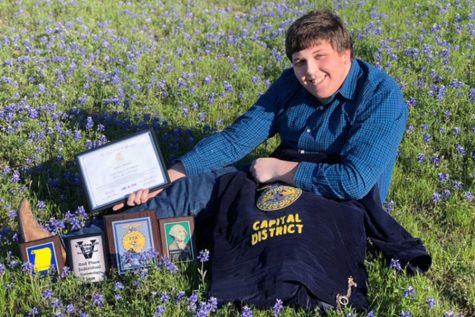 After competing in many competitions this year, senior Jeffrey Morphis poses with his awards from FFA. Morphis competed in multiple categories, including Entomology, Chapter Conducting, FFA Quiz and Swine Skillathon.