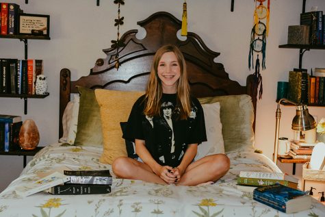 Posing in her room, senior Kieren Garner smiles while being surrounded by books. Garner plans to major in English at Texas State in the fall.