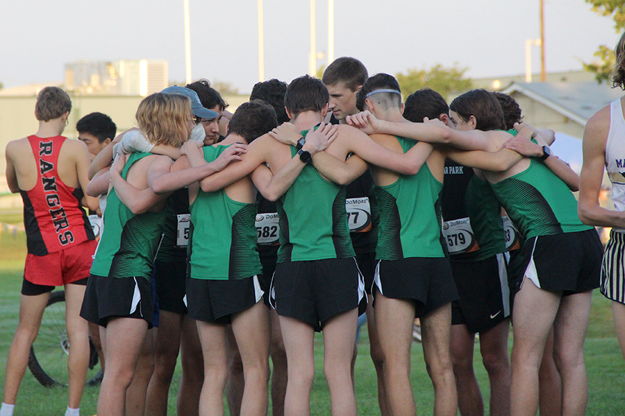 Senior Garrett Gray huddles with the varsity boys team as they get ready to race during the Cedar Park Invitational on Sept. 12. "We are ready for district and beyond later in the season" Gray said. 