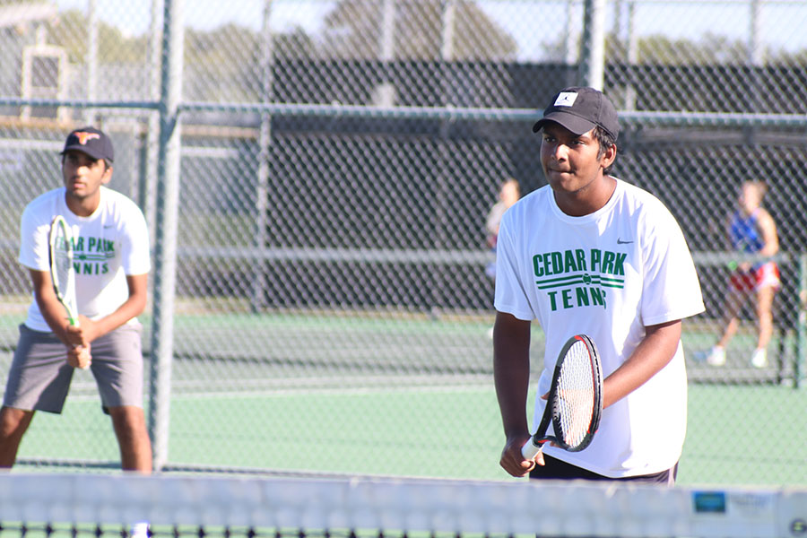 Senior Rahul Kannam prepares to hit the tennis ball at the tennis match vs. Leander. The matches have helped us become more united in working together, Kannam said. Even with [COVID] we are still able to hit and have fun so Im thankful for that.