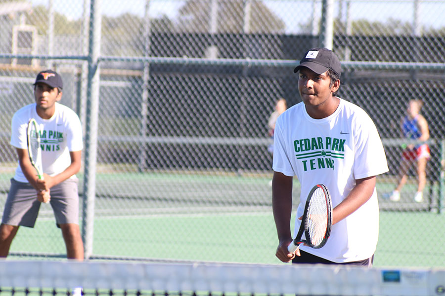 Senior Rahul Kannam prepares to hit the tennis ball at the tennis match vs. Leander. "The matches have helped us become more united in working together," Kannam said. "Even with [COVID] we are still able to hit and have fun so I'm thankful for that."