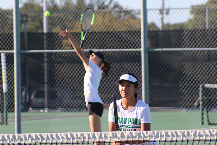 Taking a stance, freshman Danielle Tran gets ready to strike the ball at any moment during the tennis district championship on Oct. 16. The tennis team made it to the first round of playoffs and placed second in district and, according to Tran, was able to step up in terms of leadership and grew as a whole, and the players, including Tran herself, experienced growth in their abilities. For me, I had grown not only in skill, but also in mindset ever since I walked in for the tryout tournament this year, Tran said. While being selected for varsity was [a] phenomenal [achievement], constantly improving my technique, consistency, and endurance took a lot of dedication. Getting stuck on certain drills and the frustration that came with it required unwavering commitment to overcome. What really made [my experience] the highlight of my year were my friends, including my doubles partner, and the unforgettable time we shared.”
