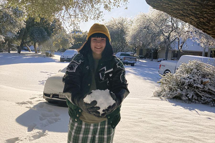 Wearing several layers in the cold, junior MJ Kelly plays with the snow at her house the first day it snowed on Jan. 10. Kelly never expected it to snow in Texas, so she wanted to spend as much time as she could in the snow. It was really cool and exciting to experience snow in Texas, and this might be a once in a lifetime opportunity, Kelly said.