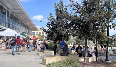 The Texas Farmers’ Market at Mueller is open Sundays with fresh produce, delectable food, refreshing drinks and a delightful atmosphere. In the building pictured, there are many booths that cater to food products. There is also seating areas and a fountain. Photo by Madison Shields