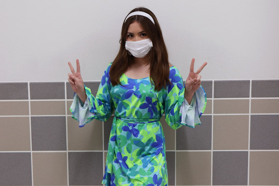 Posing with two peace signs, junior Katelyn Orozco dresses up in 1960s fashion for throwback Thursday. Spirit week also consists of Pajama Day, Rush Day, Character Day and Green Out. “I’ve been planning my outfit for a really long time now,” Orozco said. “I love dressing up in clothes from other eras.”
