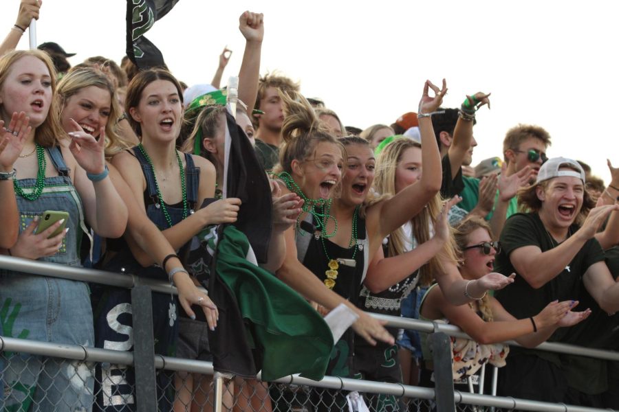 Screaming on the sidelines, seniors cheer on the T-Wolves at the Homecoming game on Sept. 3. Students dressed in green, white and black, wore their senior overalls and brought spirit gear such as flags and bullhorns to show their spirit to the other team. Im so happy our Homecoming game was early this year, senior Rowan Rodriguez said. It was great starting the season off with a loud student section and a great victory for our team. 