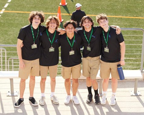 From left to right, seniors Aidan Johnson, Brady Allen, Cyrus Van Sickle, junior Braeden Fuller and senior Ryan Taylor pose for a picture at the first football game of the season. After posing for the quick picture, they grabbed water for the Celebrities. “I like being able to help the team with everything they need, Taylor said. “I think serving people brings a lot of joy into my life and so being able to do that for many people is awesome and being able to be close up with the team watching them perform is a whole new level of experience.” 