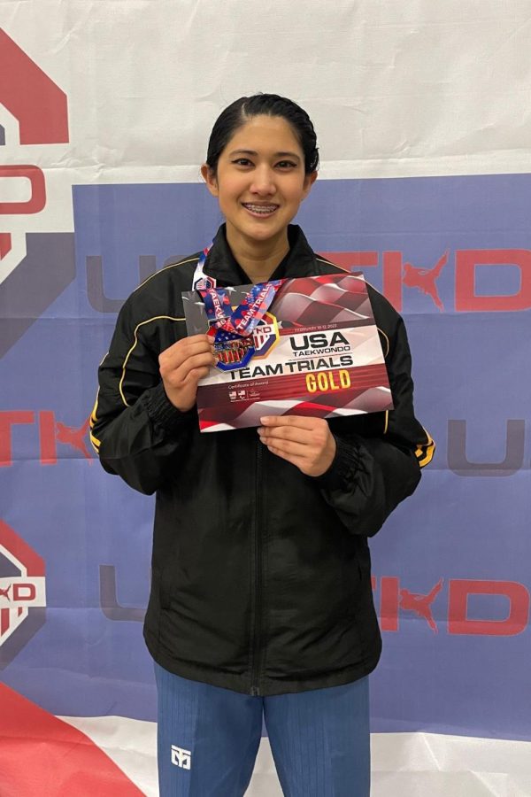 Posing+with+her+USA+gold+medal%2C+junior+Aahana+Mulchandani+holds+the+certificate+verifying+her+place+on+Team+USA+Taekwondo+team.+Mulchandani+will+represent+the+team+this+April+in+the+Dominican+Republic+for+the+Pan+American+Taekwondo+Championships.+%E2%80%9CIm+really+excited+to+go+%5Bto+the+Dominican+Republic+because%5D+Ive+never+been+there%2C%E2%80%9D+Mulchandani+said.+%E2%80%9CIm+a+little+bit+nervous+too%2C+%5Bbut%5D+I+feel+very+honored+to+%5Bcompete%5D+because+I+fought+so+hard+%5Bto+make+the+team%5D.+I+have+a+very+%5Bgood%5D+shot+%5Bat+winning%5D+if+I+do+my+best.+My+coach+would+probably+kill+me+if+I+didn%E2%80%99t.%E2%80%9D+%28Photo+Courtesy+of+Aahana+Mulchandani%29