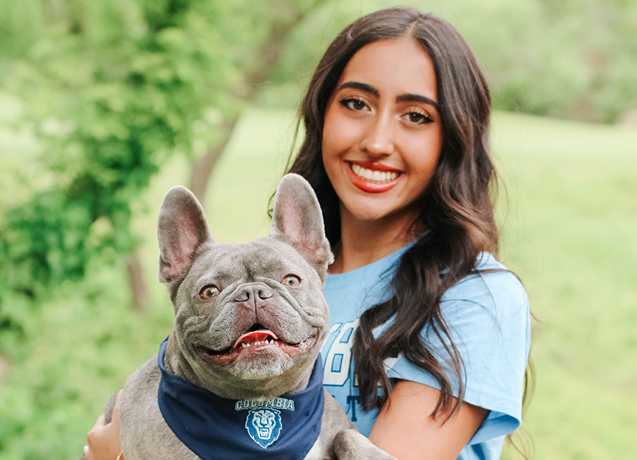 Holding her dog, Nova, senior Ariana Balakrishnan poses for her senior pictures while Nova wears a bandana with her college decision. Balakrishnan applied to 18 colleges in total, but she decided on Columbia in the end. “Right before I clicked the button to open Columbia’s letter, I literally looked at the camera and go ‘This is just gonna really suck because I wanted it so bad,’ and I clicked it and all of a sudden you hear trumpets,” Balakrishnan said. “There’s a video that plays when you open it and I actually didn’t watch the video, I just watched the screen go black, because every day of December before ED [Early Decision] I would go on YouTube and watch the acceptance video to manifest it, so immediately when the screen went black, I started screaming and jumping up and down. And my parents in the video are like ‘What are you doing, where’s the letter,’ and I was just screaming ‘I got in, I got in.” I just started crying, and it just felt like everything in the world came together.”