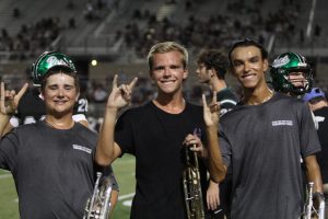 Holding up the Timberwolf hand sign after performing Metal Shop at halftime, seniors Austin Waldbusser and Connor Daly pose with sophomore Andrew McCarthy.The three band members spent their summer with Dum Corps International, a non-profit that is known to be the highest level of marching band available. “One [of the reasons for joining] just watching [DCI Corps] shows and being kind of a band nerd about it in general was cool and being like ‘I want to do that’,” Daly said. “Then, one of the now alumni, went to march in the corp of The Phantom Regiment last year, and I was like well ‘I can do it, someone else I know can do it, may as well try it.’”