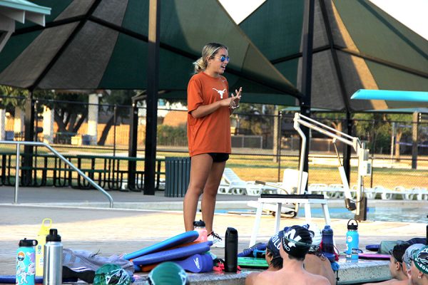 Starting the early morning practice, new swim and dive coach Kyla Gargiulo informs her student-athletes of their next set, giving them tips to help along the way. Gargiulo looks forward to keeping the swim team competitive and improving throughout the year. “The thing I love most about coaching is getting to be a part of the sport that I fell in love with,” Gargiulo said. “[I also love getting to] help the current team achieve and surpass their goals while having fun.”  Photo by Kaydence Wilkinson
