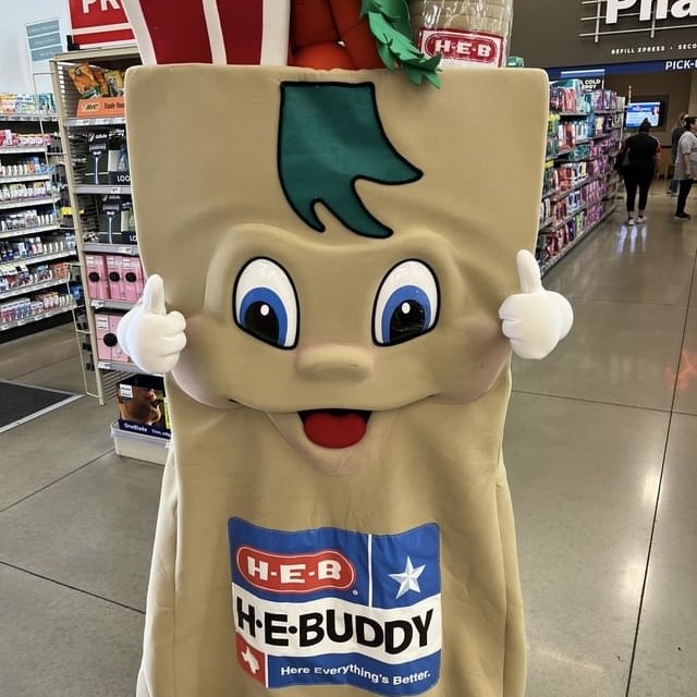 Dressed as “H-E-B Buddy,” senior Logan Hedges entertains shoppers during a shift at H-E-B. Hedges has fun on the job, as there’s significantly less pressure than other jobs he has had. “I [used to umpire] little league baseball, and it’s definitely less stressful,” Hedges said. “There’s not much [that can go wrong] scanning groceries. Making a bad call in baseball is so easy.”
