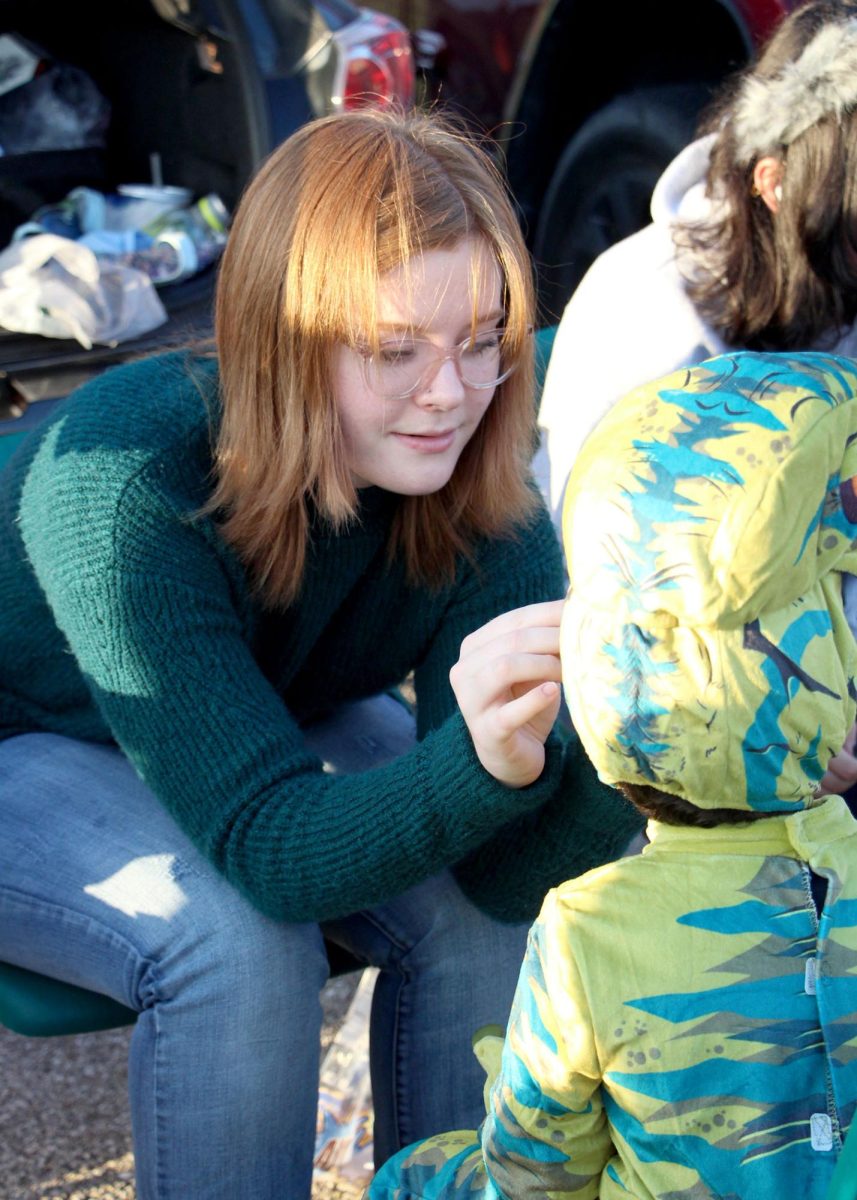 As kids excitedly run up to their booth, Art Club member and senior Vivien Jennison provides free water tattoos for the hopeful dinosaurs and spidermen during the Trunk or Treat. This event lasted from 5:30 to 7:30 pm, and at it, kids received candy and participated in many types of activities and games. “It was really fun,” Jennison said. “The turnout was very large, which was unexpected because it had rained that day, but it was really fun and all the kids were very cute.”