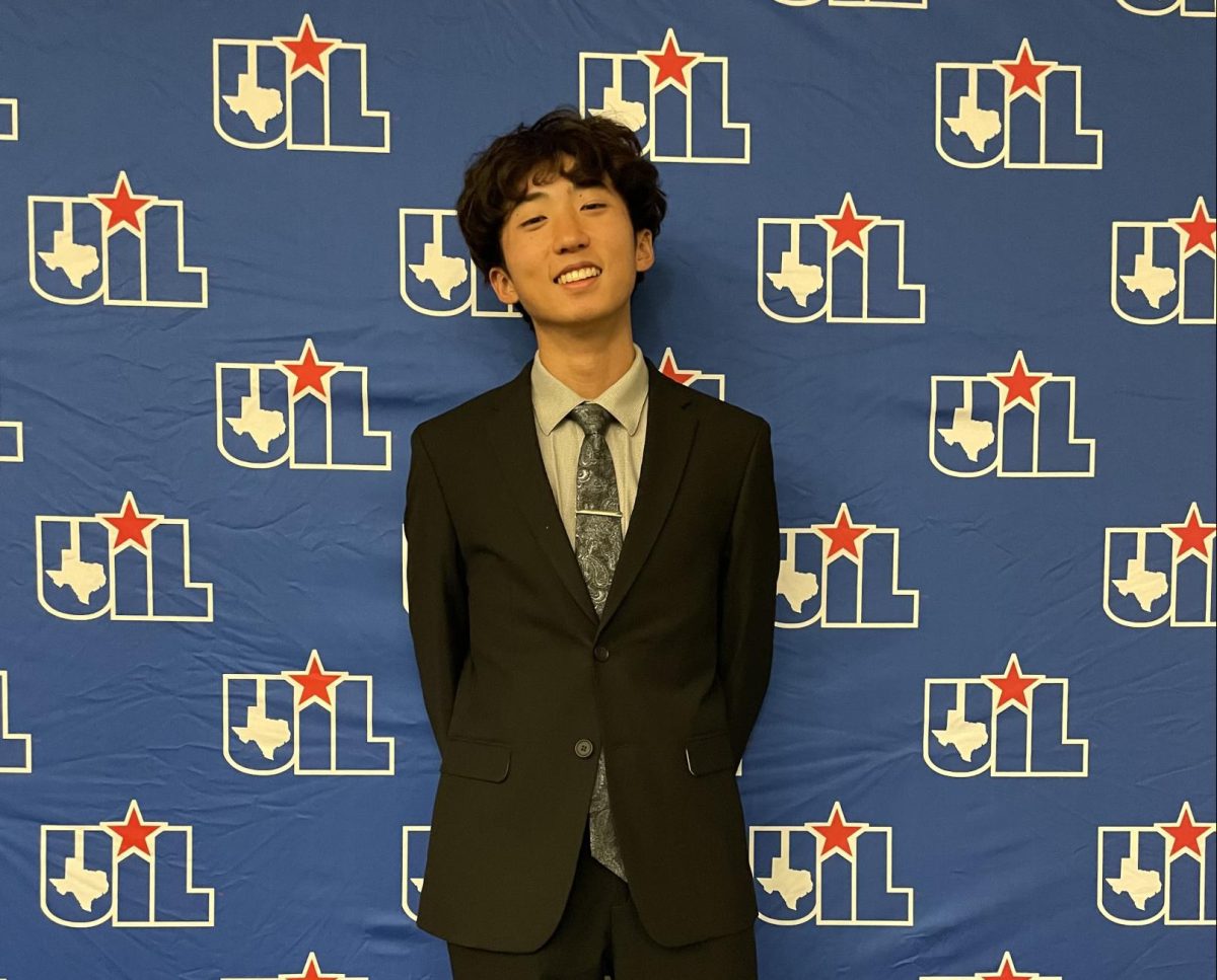 Standing in front of the UIL banner, senior Nathan Li poses for a picture at the state debate competition held on Jan 10-11. Li competed in the Congressional debate event and out of the 18 competitors Li went up against he placed 9th and did not make it to the final round. “In terms of what it offers to everybody, congress is a good lense into how our government works,” Li said. “We use actual congressional procedure and it helps people stay informed because people have to look at a lot of different topics.”
Photo courtesy of Josh Marsh, used with permission
