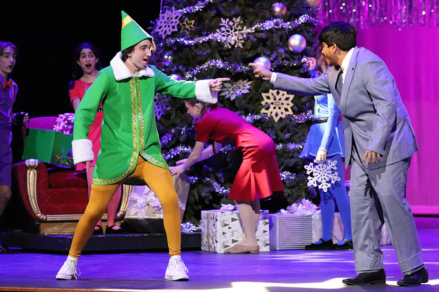 Pointing at each other, junior Krishnan Muthukumar and senior Aidan Cox sing about holiday joy in their song “Sparklejollytwinklejingley.”  Theatre performed a scene from their winter musical Elf during the Celeb Holiday Show to encourage the audience to attend the play the following week. “That scene was awesome,” Muthukumar said. “I got to share the stage with one of my closest friends. I really enjoyed that whole number and just hanging out with him. He’s really talented, so it was such an honor to share the stage with such an awesome person.” Photo courtesy of Lilly Adams, Tracks Yearbook Staff