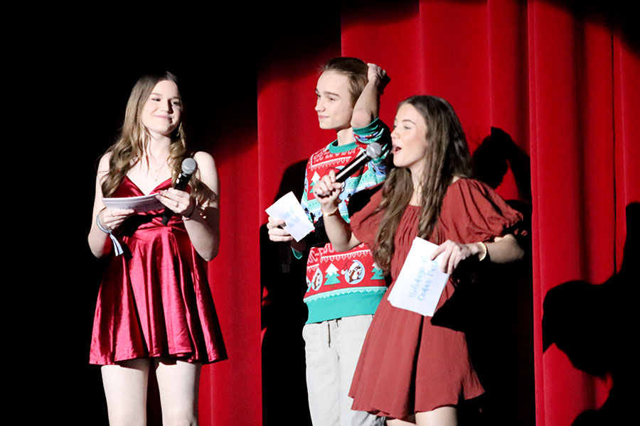 Introducing one of the performances in the first act, sophomore and Celebrity manager Kyra Cox stands with sophomores Reid Cummins and Lulu Lynch in front of the audience. Cox is not only a part of Celebrities, but is also an anchor on the CPHS Wolfcast and helped host the Holiday Show. “It was fun,” Cox said, “My favorite part of the night was getting to be a part of both of my organizations, Celebs and broadcast, simultaneously.” Photo courtesy of Lilly Adams, Tracks Yearbook Staff