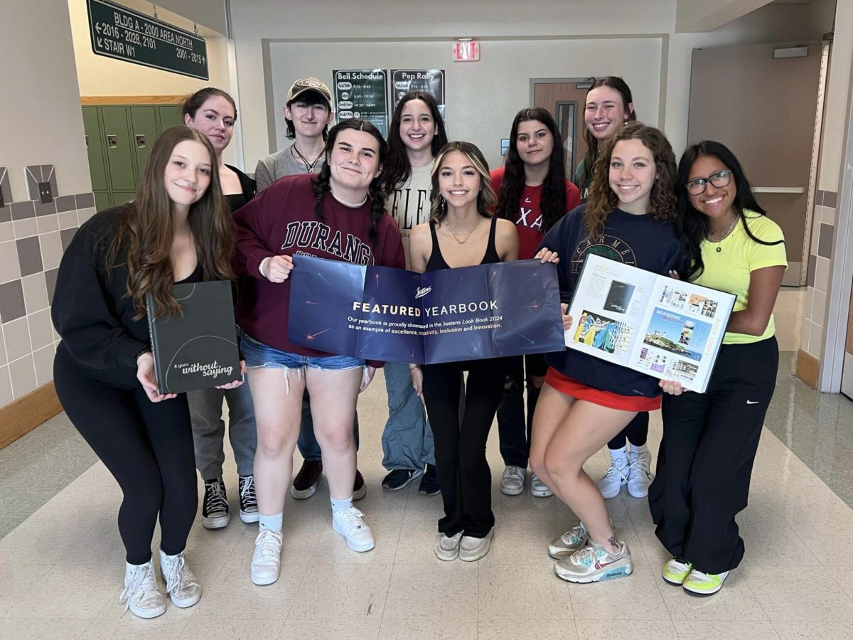 Posing with their “Featured Yearbook” banner, signifying that the 2022-2023 yearbook is used as an example for other yearbook classes, the yearbook team smiles at the camera. Yearbooks have been on sale for $80 all school year, with 90 left in stock. “Im really happy with this book,” content editor and senior James Sanderson said. “I think other people are going to be happy with it; all our pages look really cute. Issues are a thing, but we have them every single year and we dont let them get in the way. We work on a very, very tight schedule and theres no pushing deadlines back. It’s a lot of fun, though. It is such an amazing staff and a very engaging team. Its very fulfilling work.” Photo courtesy of Paige Hert