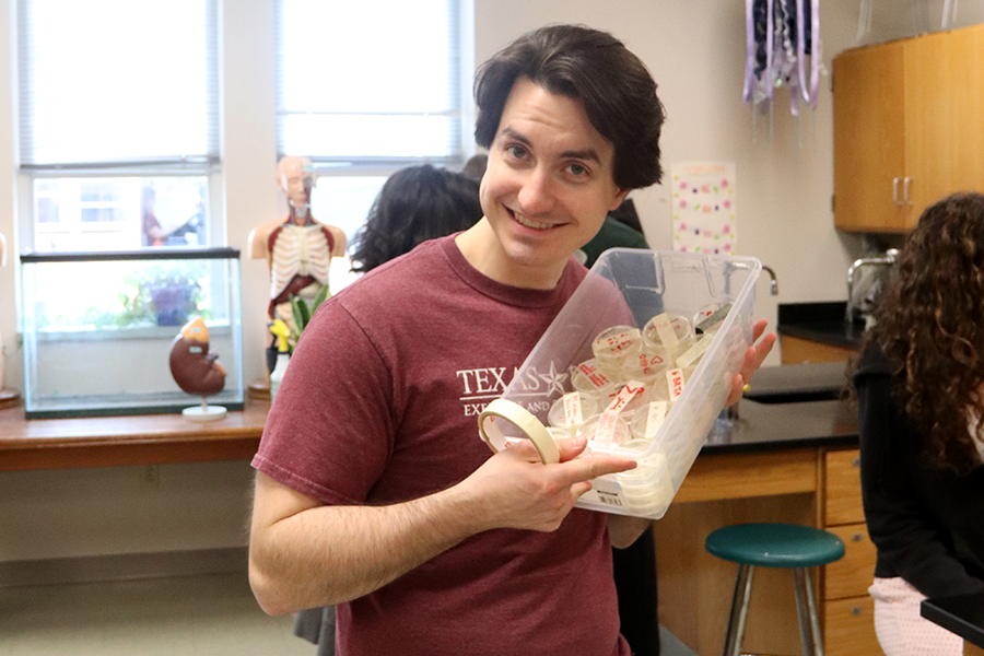 Holding a bucket of materials in one hand and a roll of tape in another, anatomy and biology teacher Tyler Terry prepares for a lab. Terry said his proudest moments are when his students are happy to see him. “When I take my wife to a football game or something and a bunch of students want to say hi to me or they like to smile and wave and it just makes me feel good that the students are really kind and supportive of me,” Terry said. “[I’m also] proud when I see students perform really well in their extracurriculars because I can see how hard they’re working in my classes, [so] when I see that they’re also working so hard in other things. Like they’re winning band competitions or they’re getting awards for their theater productions, or I see them put on their choir shows, that’s like, wow, you guys are incredible.”