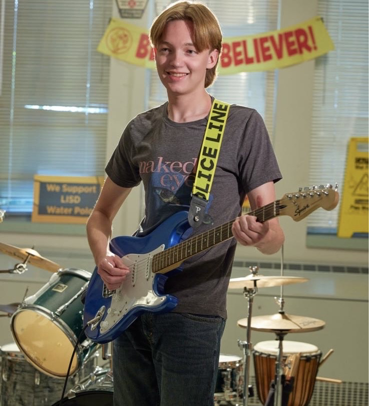 Standing with his guitar during Garage Band practice, senior Trevor Von Wupperfeld smiles for the camera. Von Wupperfeld was a founding member of the club, along with a long line of other activities at Cedar Park that earned him the title of Most Involved. “All of the music programs at our school are very, very dedicated, Von Wupperfeld said. Its kind of an all or nothing type of deal. And I am not a big fan of the all or nothing. So I kinda found a garage band to house all of the musicians who didnt have a place in the school or people who didnt have a traditional instrument they played. We take guitarists and basses and all kinds of stuff.  Photo Courtesy of Trevor Von Wupperfeld