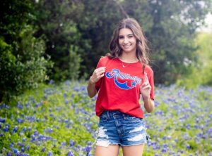 Crossing her fingers tightly, senior Sophie Triche smiles proudly for her senior photo. Triche plans to attend Kilgore college and is hopeful to continue high kicking with the Rangerettes in the fall. “When I first saw the Rangerettes, I was enamored by how professional they were,” Triche said. “It made me absolutely fall in love with them and everything they do. I knew I wanted to dance after high school and the Rangerettes to me, feels like home. I could not be more excited when I made the official decision to try out and let my friends and family know that I was committed to be a hopeful for such a world renowned dance team.” Photo Courtesy of Sophie Triche