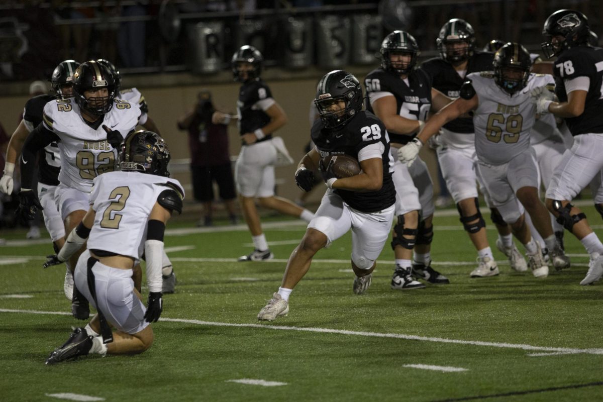 Juking out his opponents, sophomore varsity running back Lucas Viloria maneuvers around the Rouse High School defense with his field footwork. The Timberwolves beat Rouse 35-25 on Oct. 4 during the Homecoming game. “The running backs work really hard; we prepare by doing a lot of training together and lifting weights,” Viloria said. “Everytime I have the ball it feels electric. There is no other feeling than having your teammates depend on you at that moment.” Photo by Kacey Miller